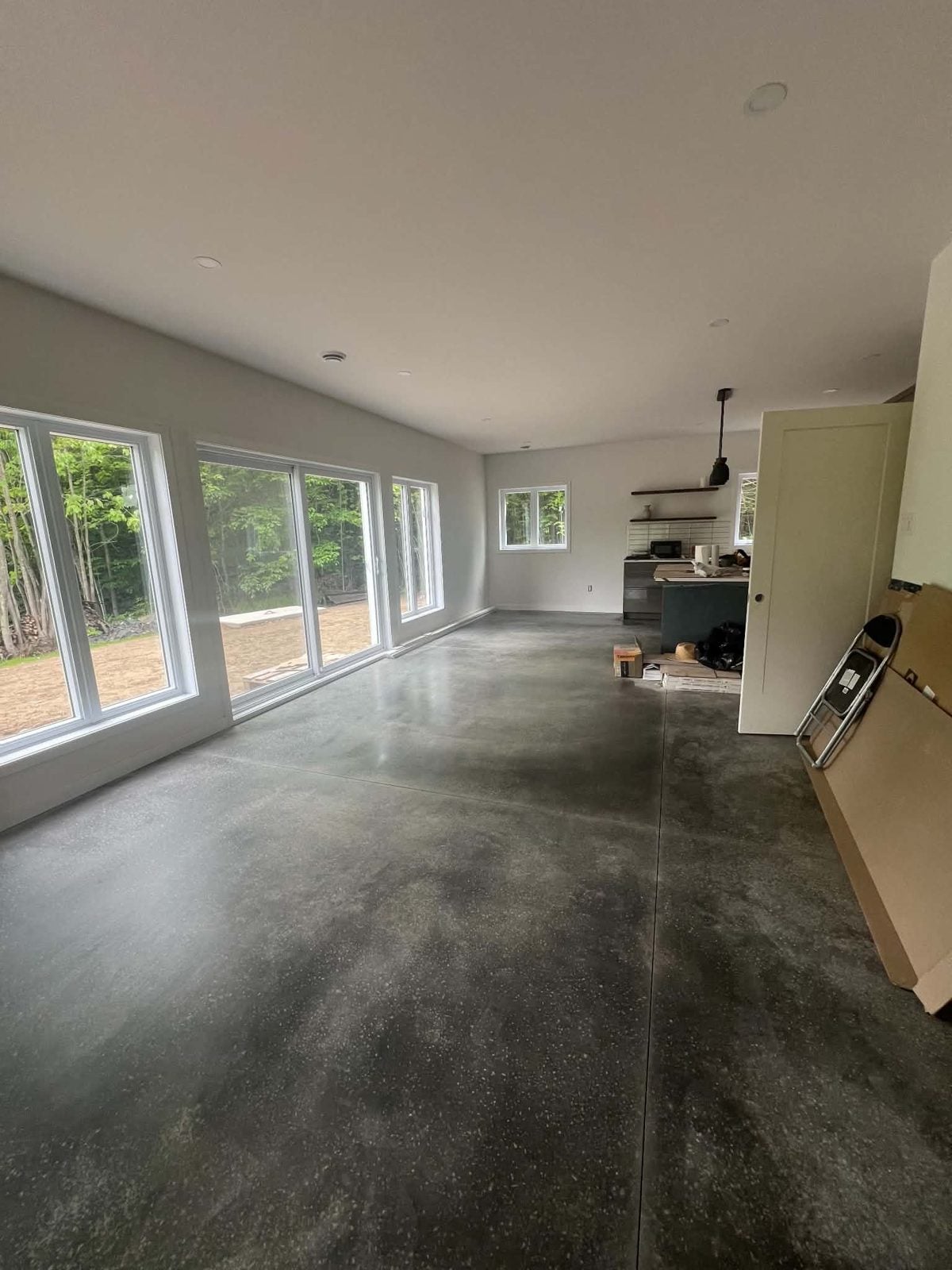 Séjour aux grandes fenêtres et au plancher de béton poli