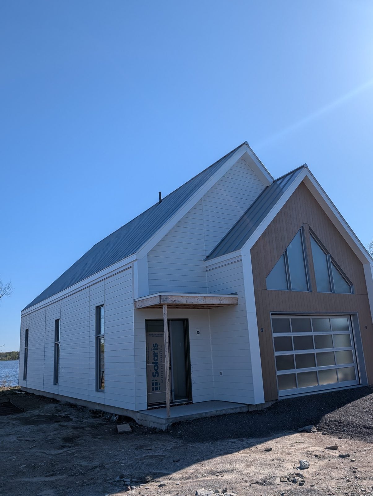 Maison neuve à pignon vitré, au revêtement blanc et de bois, dans la MRC d'Argenteuil