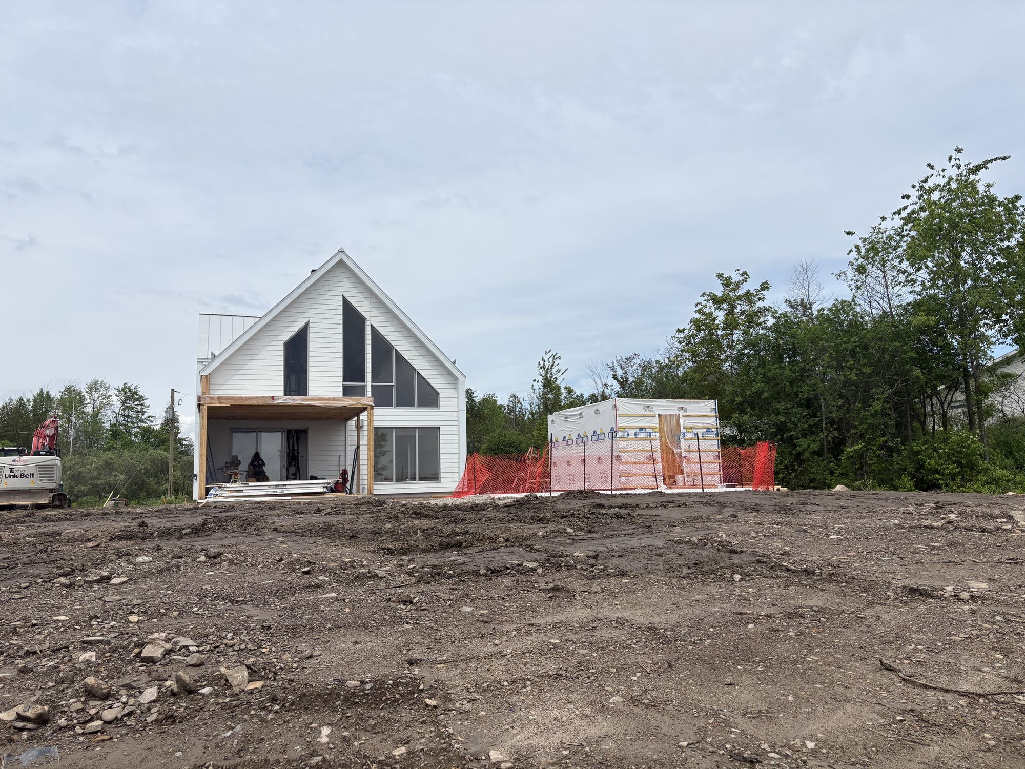 Photo du chantier : la maison neuve en construction, avec son pignon vitré et sa galerie couverte