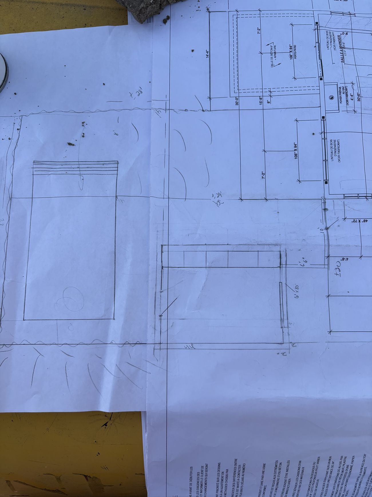 Plans imprimés annotés à la main, posés sur une table