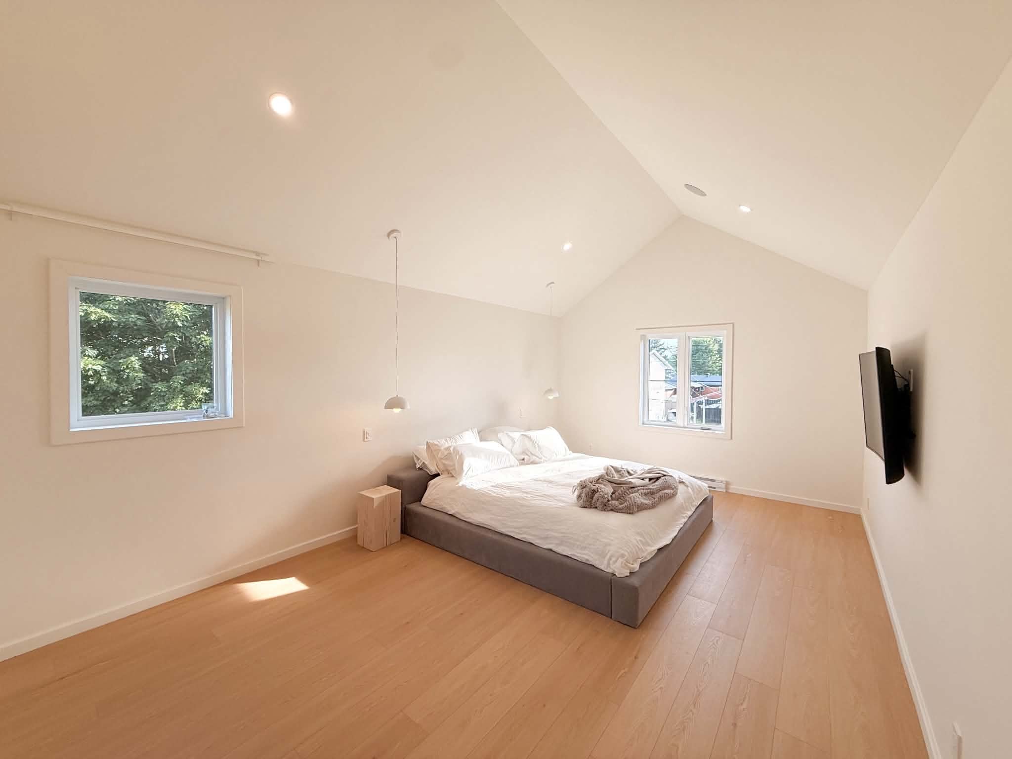 After the work: the bedroom under a cathedral ceiling, in full daylight