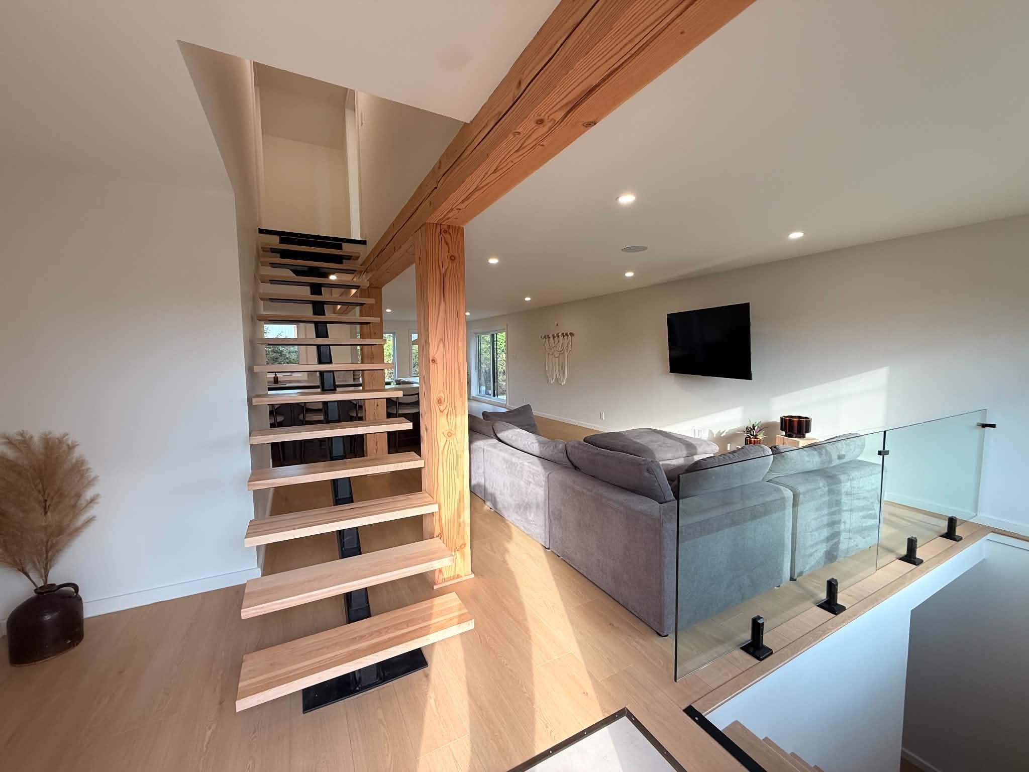 After the work: staircase and glass guardrail opening onto the living area