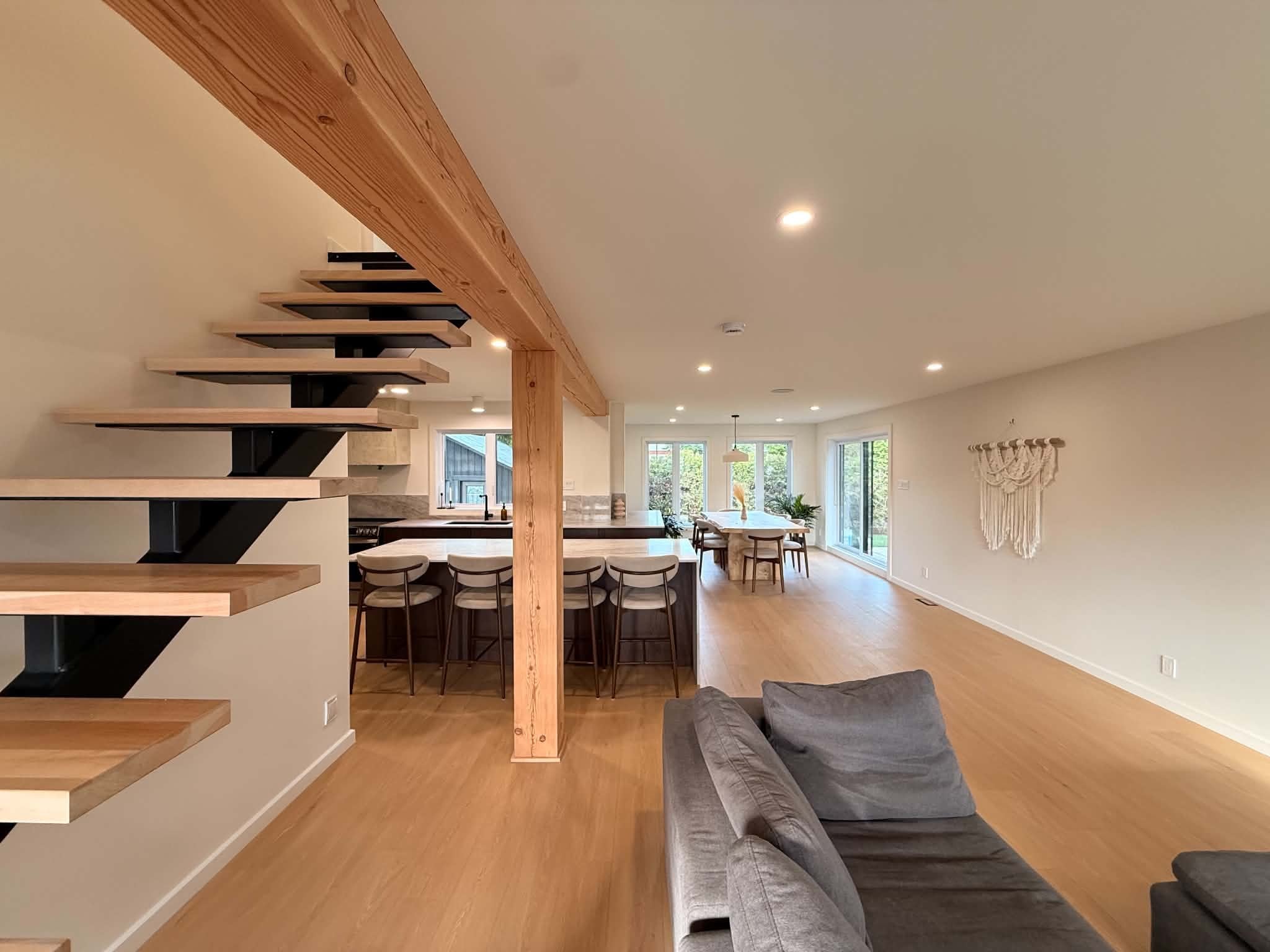 After the work: open staircase, wood post and living area through to the dining area