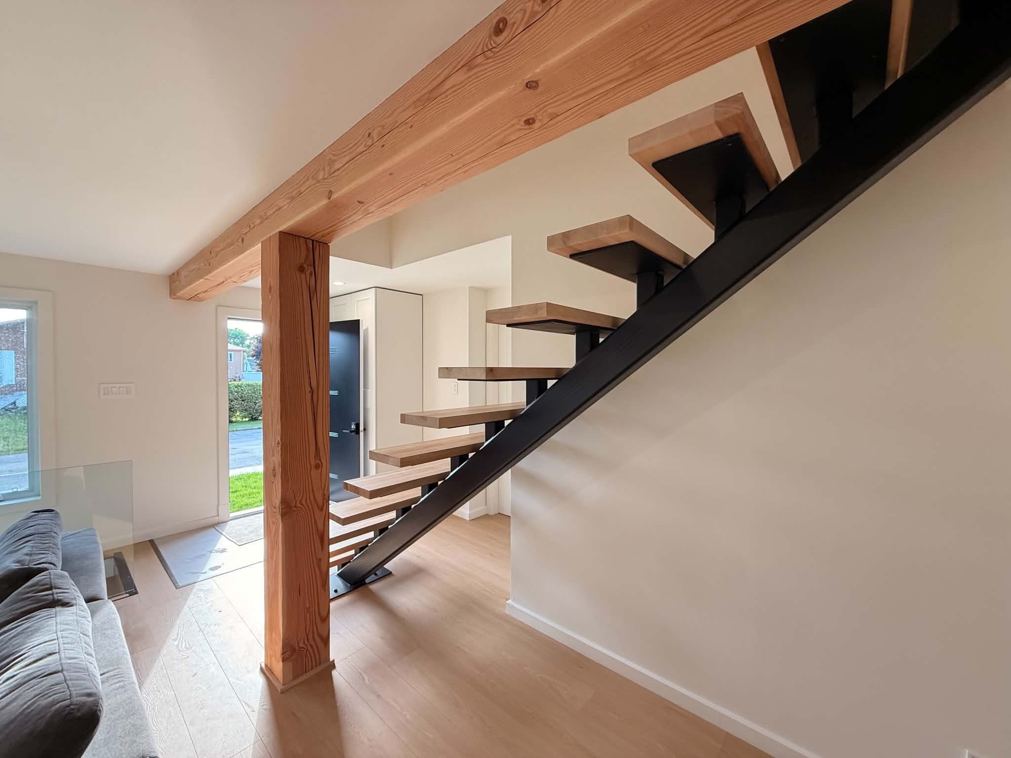 After the work: wood-tread staircase on a black steel stringer, near the entrance