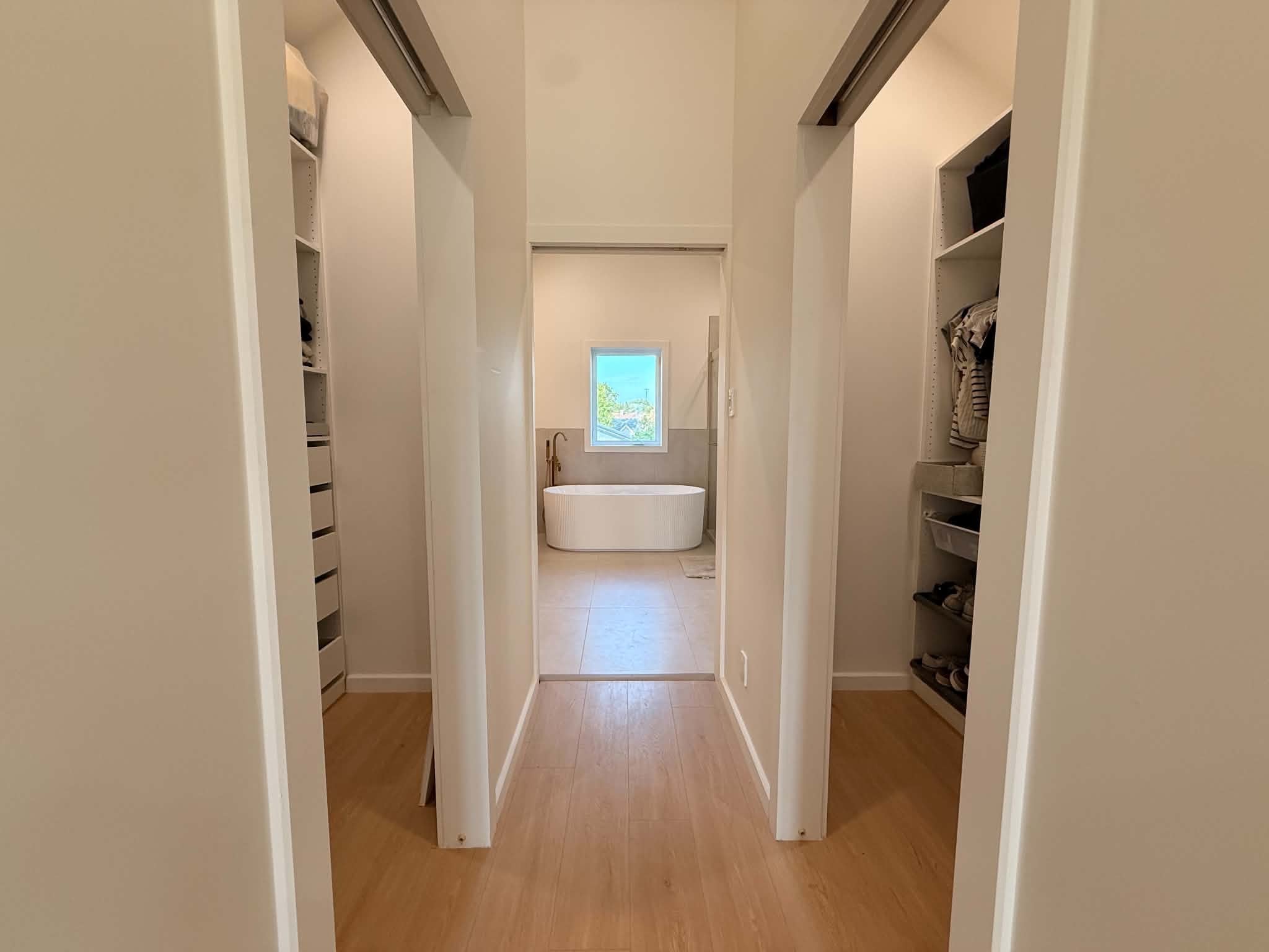 After the work: hallway between two fitted walk-in closets, leading to the bathroom