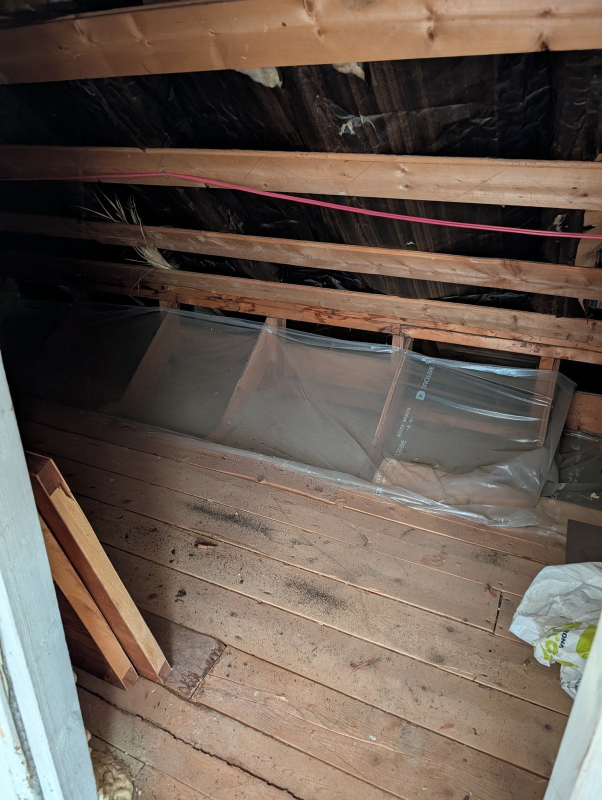 Attic before the work: plank floor, original insulation and vapor barrier