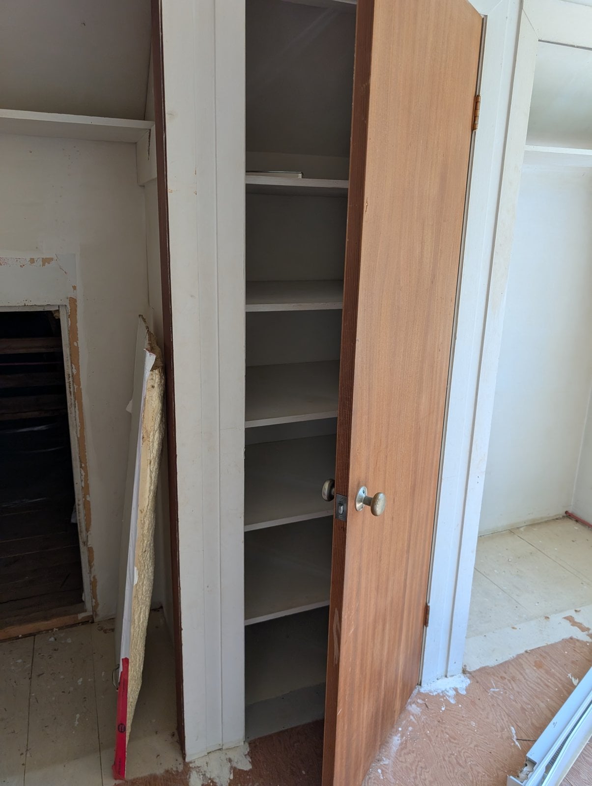 Shelved closet upstairs before the work, with the attic access hatch beside it