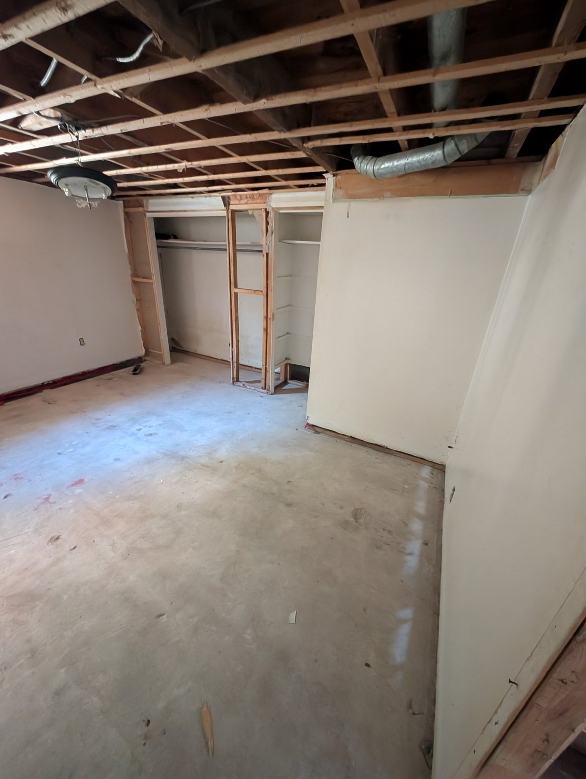 Same basement room from another angle, with a ventilation duct in the ceiling