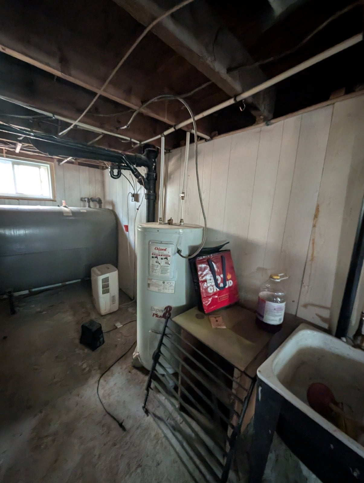 Mechanical room before the work: oil tank, water heater and dehumidifier
