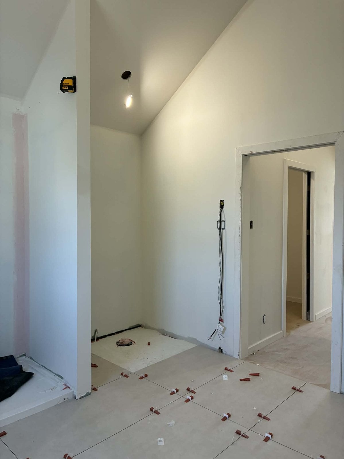 During the work: bathroom under a cathedral ceiling, large-format tile being laid